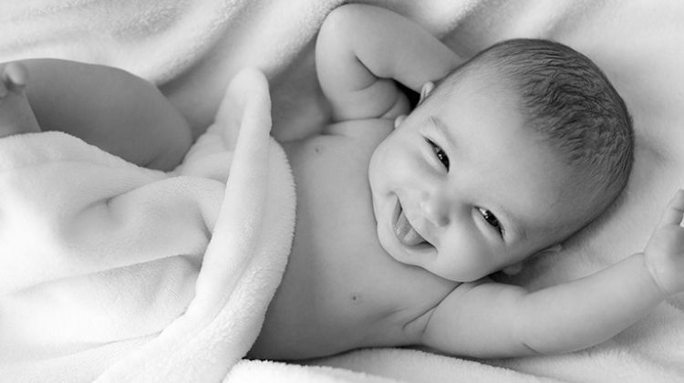 Glücklich trotz unerfülltem Kinderwunsch. Erwartungen und Wünsche eines Babys. Glückliches Baby in schwarz-weiß