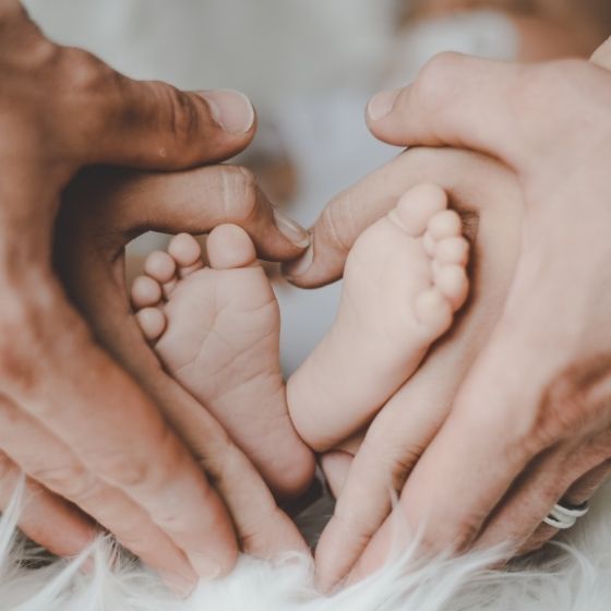 Babyfuesse in Elternhaende Wunschkind